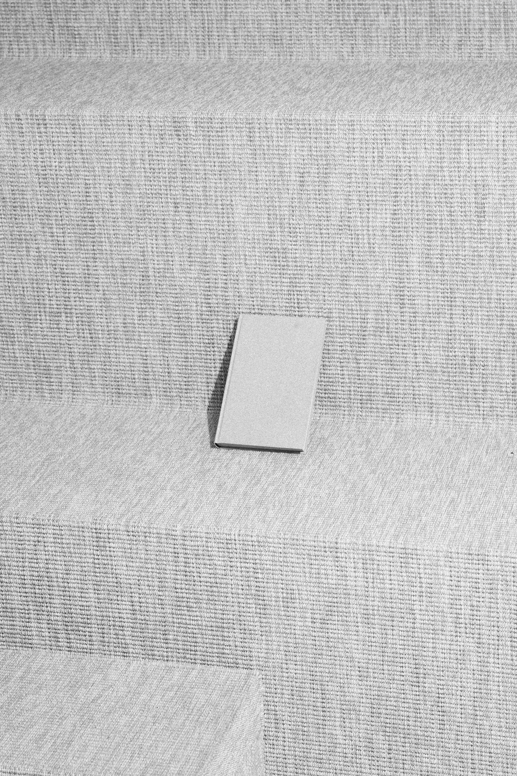 Fotógrafo le toma una foto a una libreta gris en unas escaleras grises