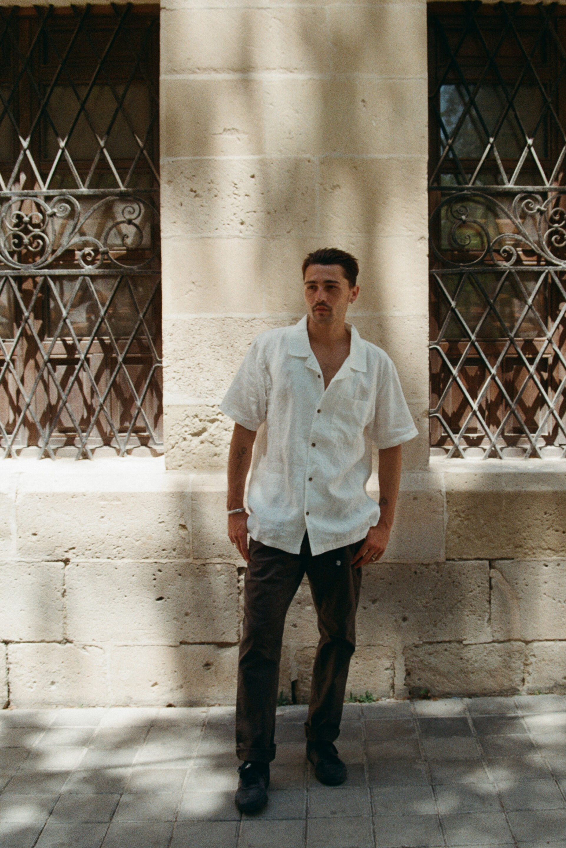 Fotógrafo le toma una fotografía a un chico posando con una camisa blanca