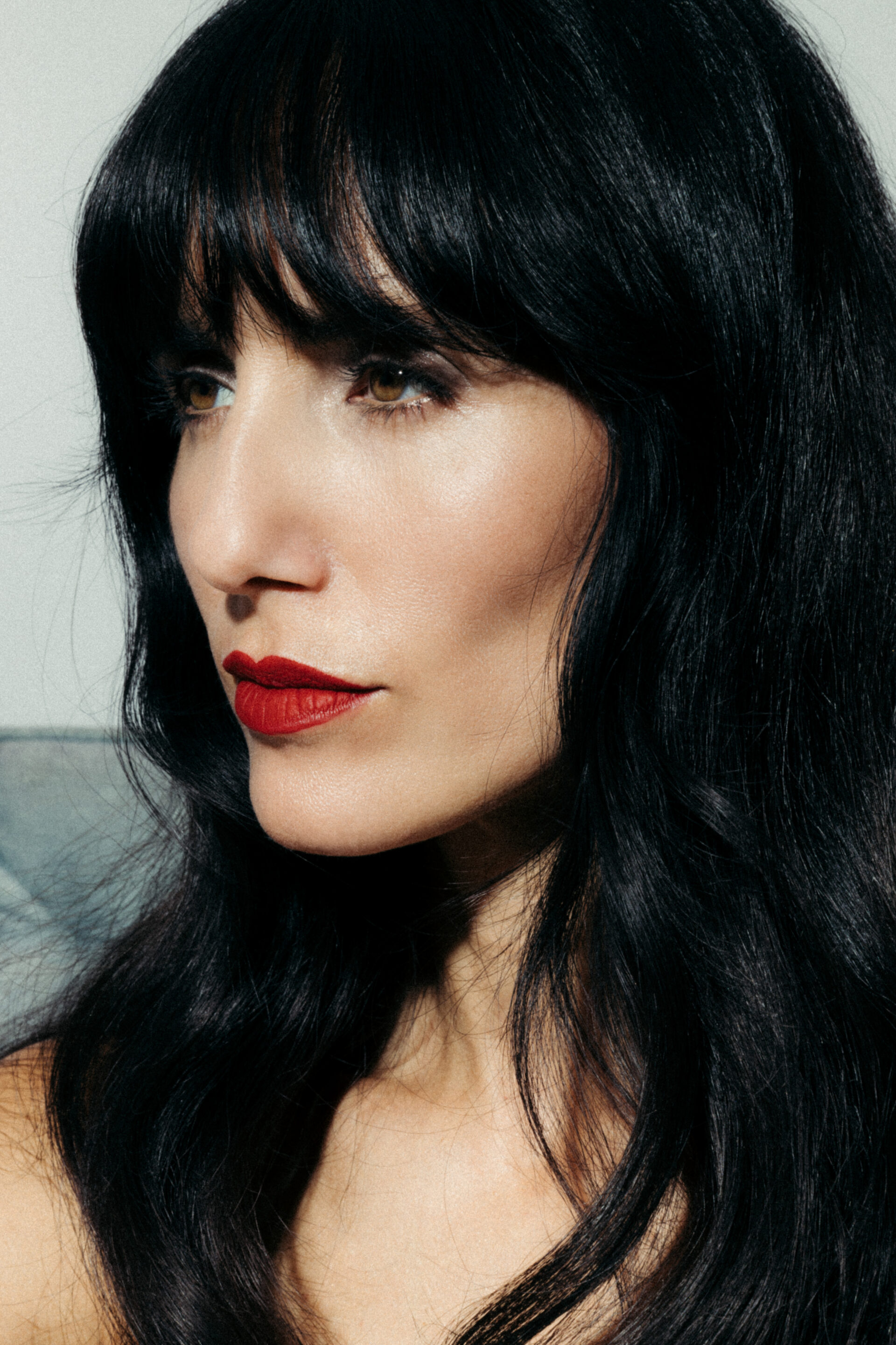 Chica posando de perfil mientras el fotógrafo le toma una fotografía