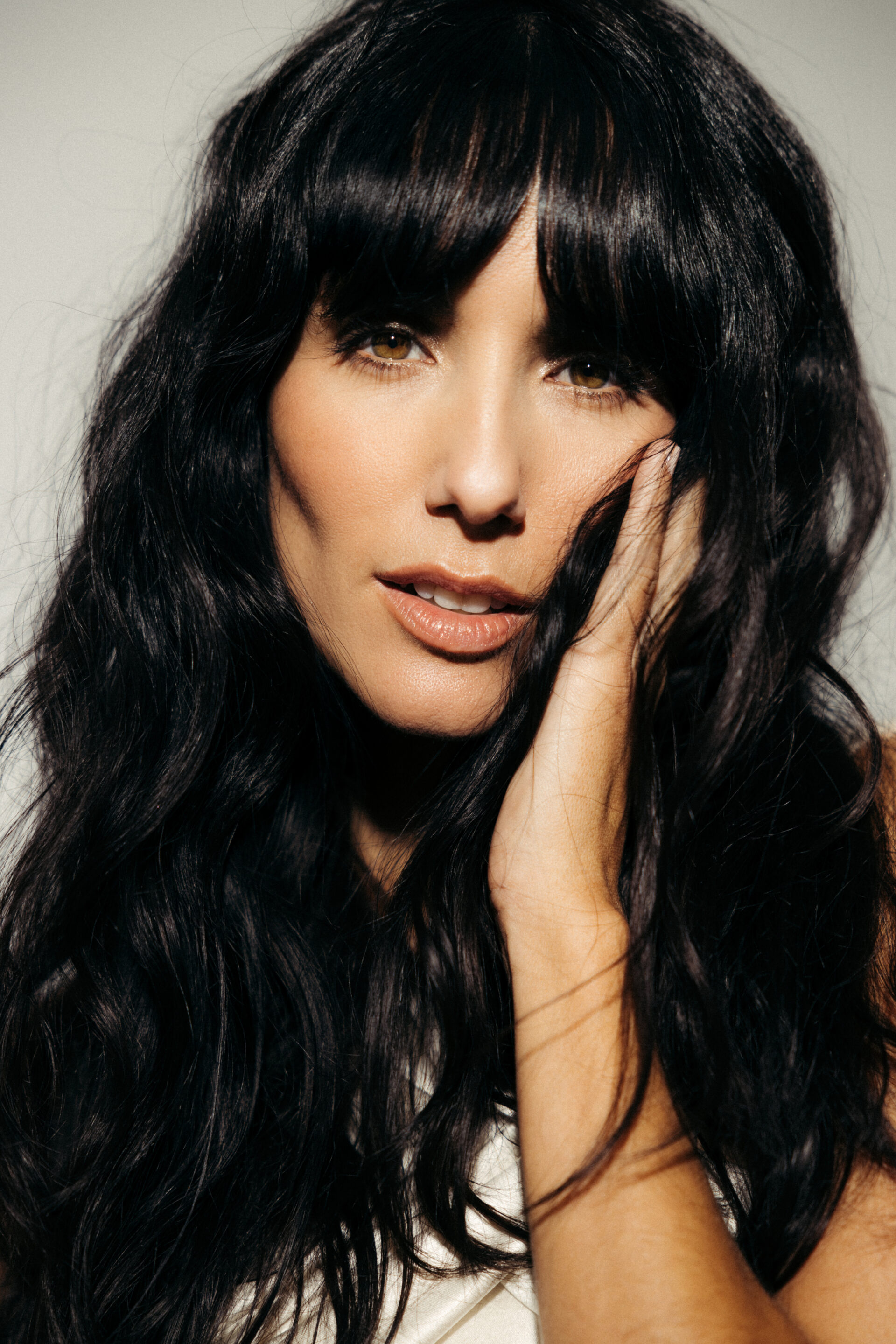 Chica con vestido cruzado posando de frente con el pelo suelto mientras el fotógrafo le toma una fotografía