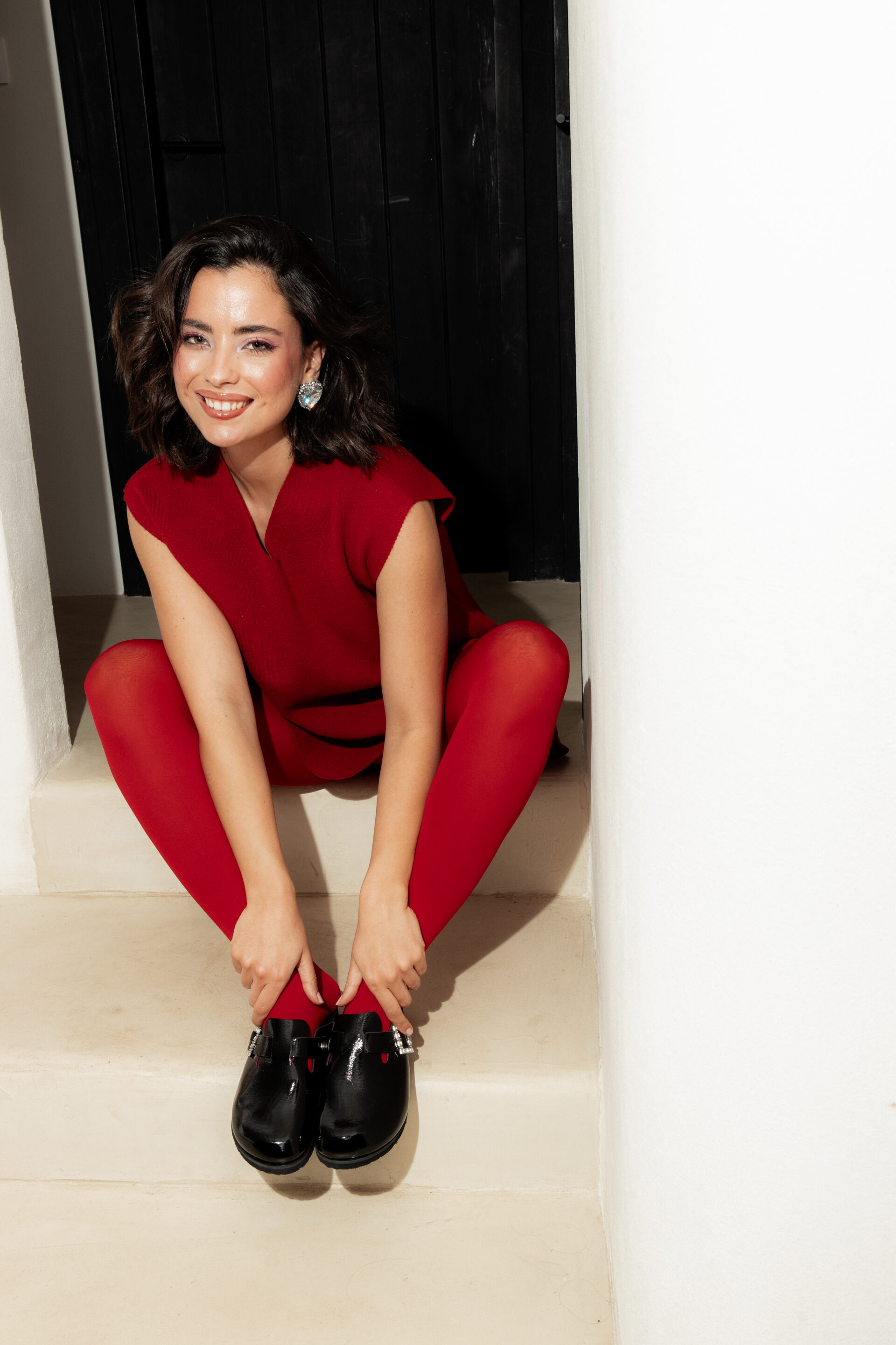 Chica en una pose con un vestido rojo y un fotógrafo tomándole una fotografía