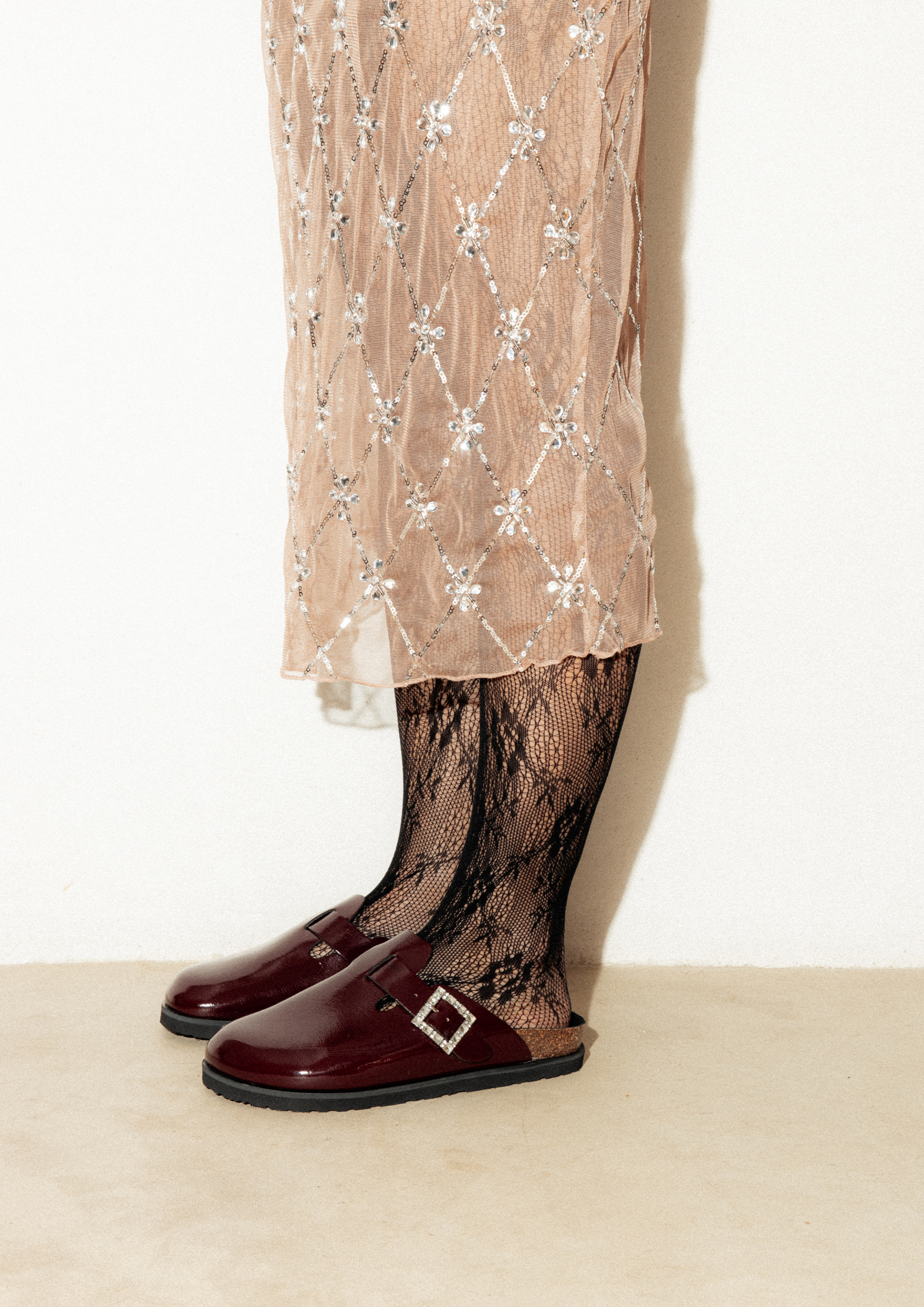 Fotógrafo le toma fotografía a los zuecos de color granate y a la falda larga de la chica