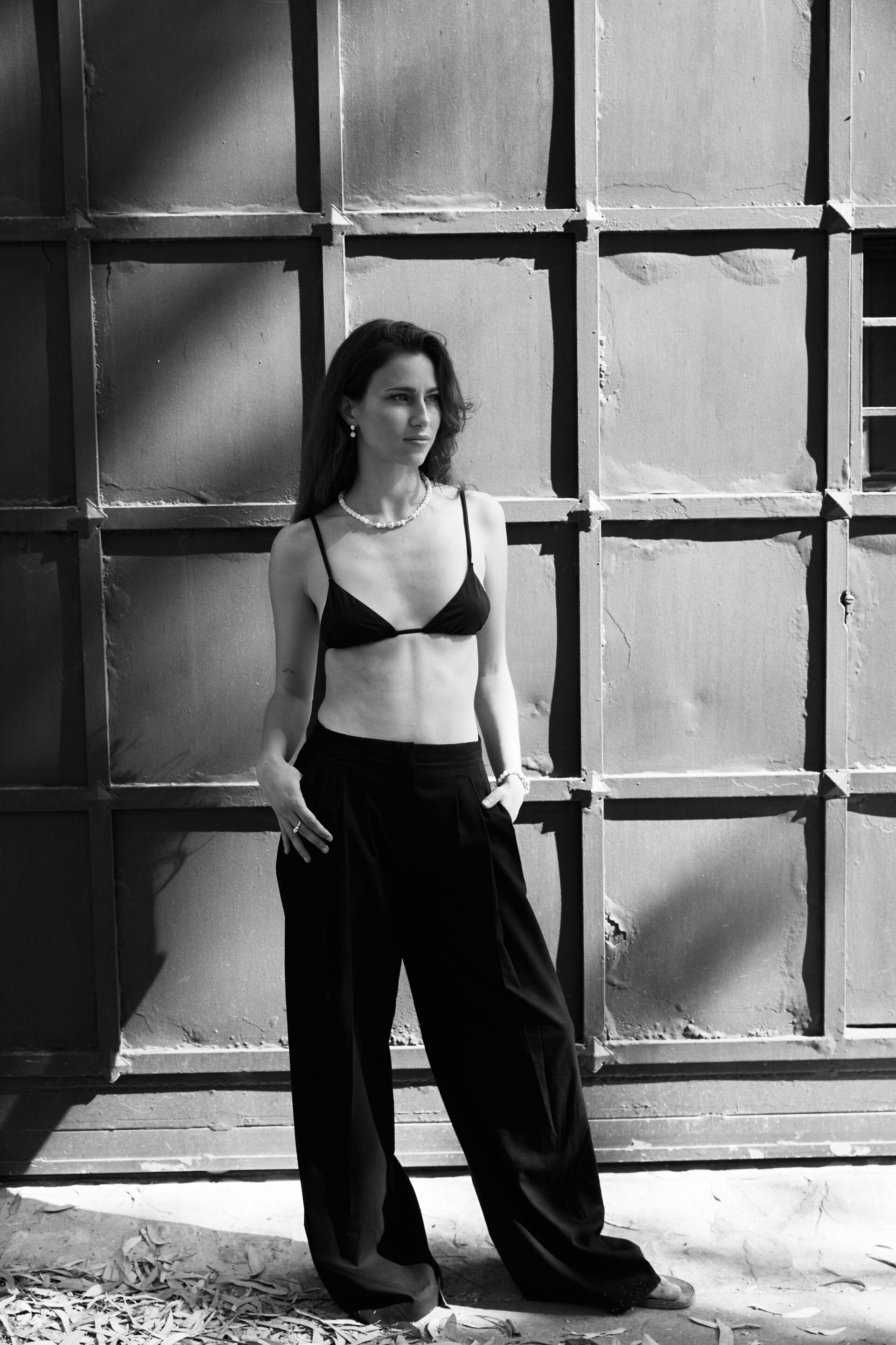 Chica con top negro posando mientras fotógrafo le toma una foto en blanco y negro