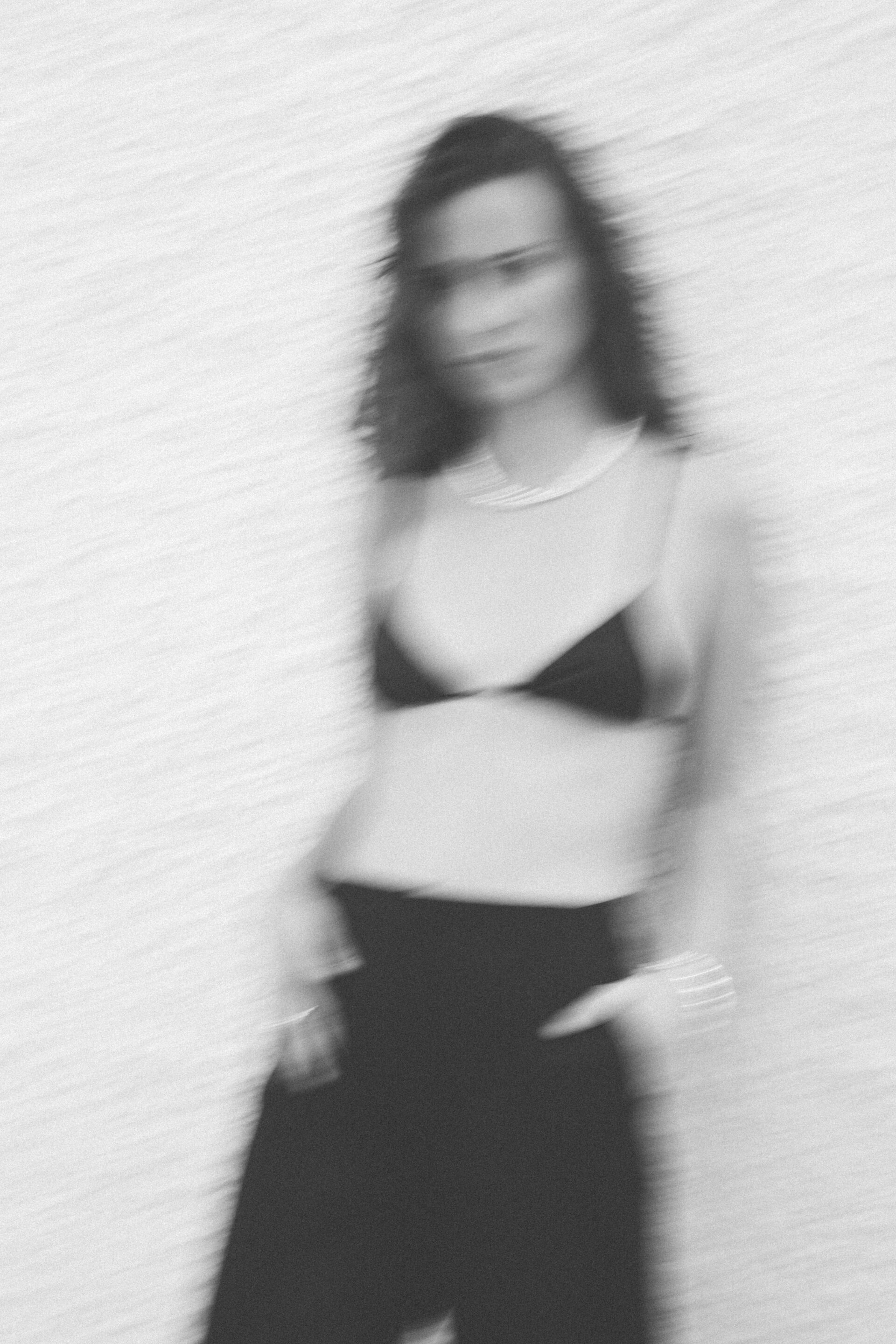 Fotógrafo le toma una foto a una chica con top negro posando en blanco y negro con distorsión