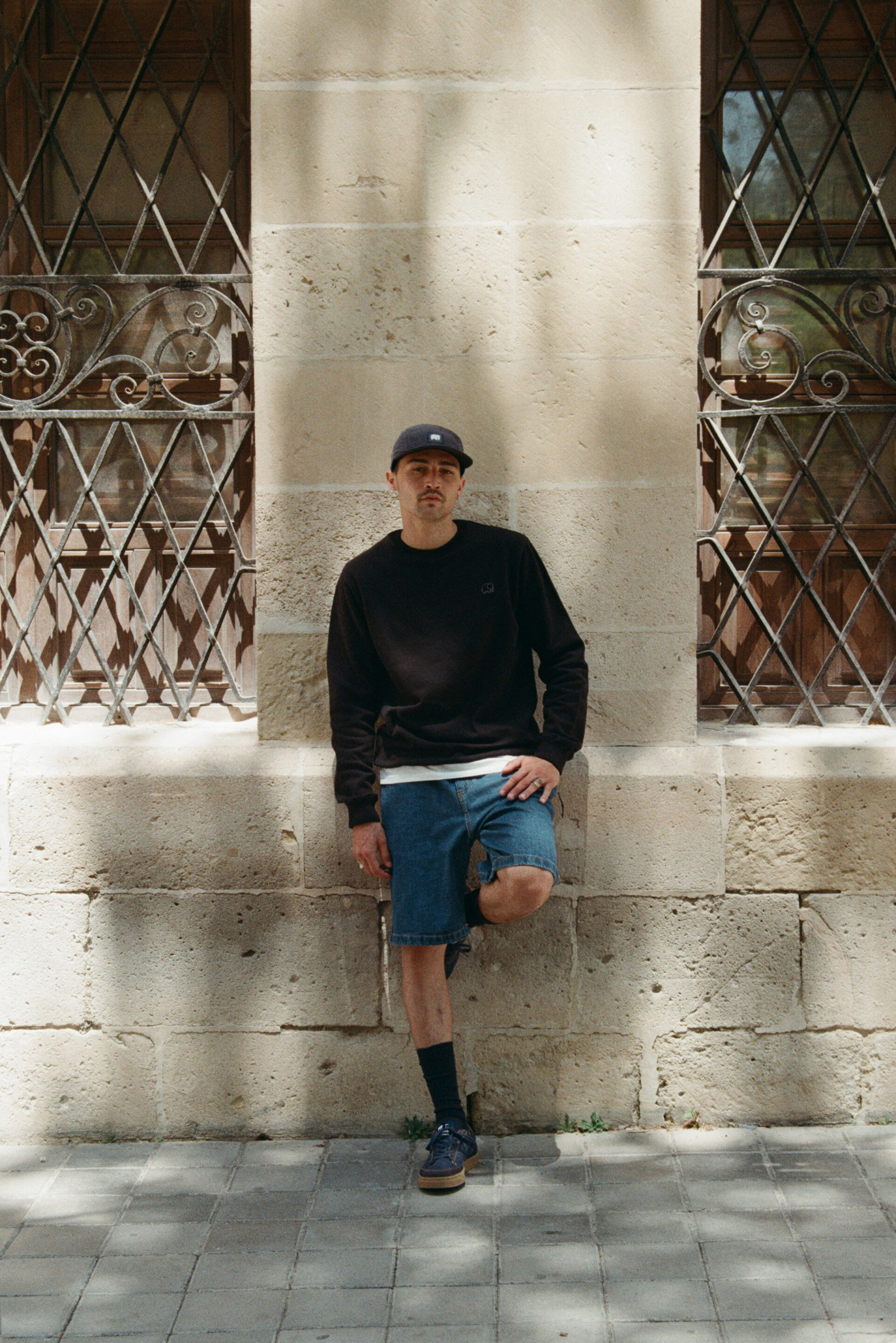 Fotógrafo le toma una fotografía a un chico con una sudadera negra y una gorra