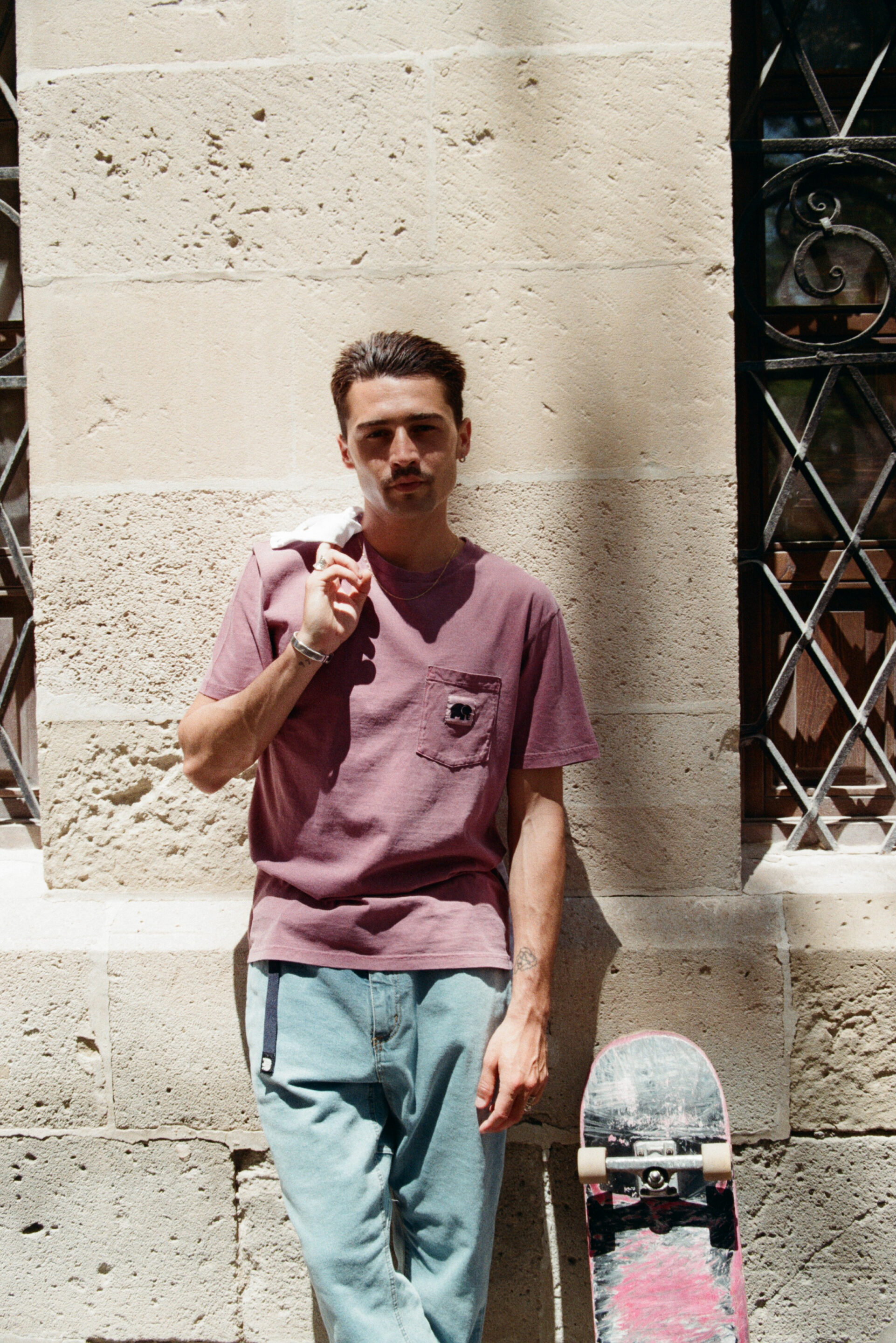 Chico posando con una camiseta rosa mientras el fotógrafo le toma una foto
