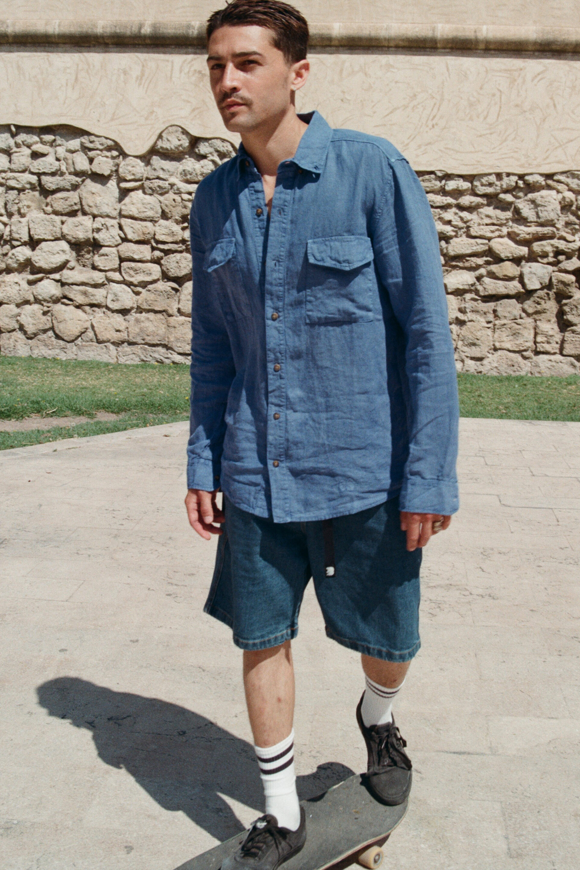Chico con conjunto vaquero en skate mientras el fotógrafo le toma una fotografía