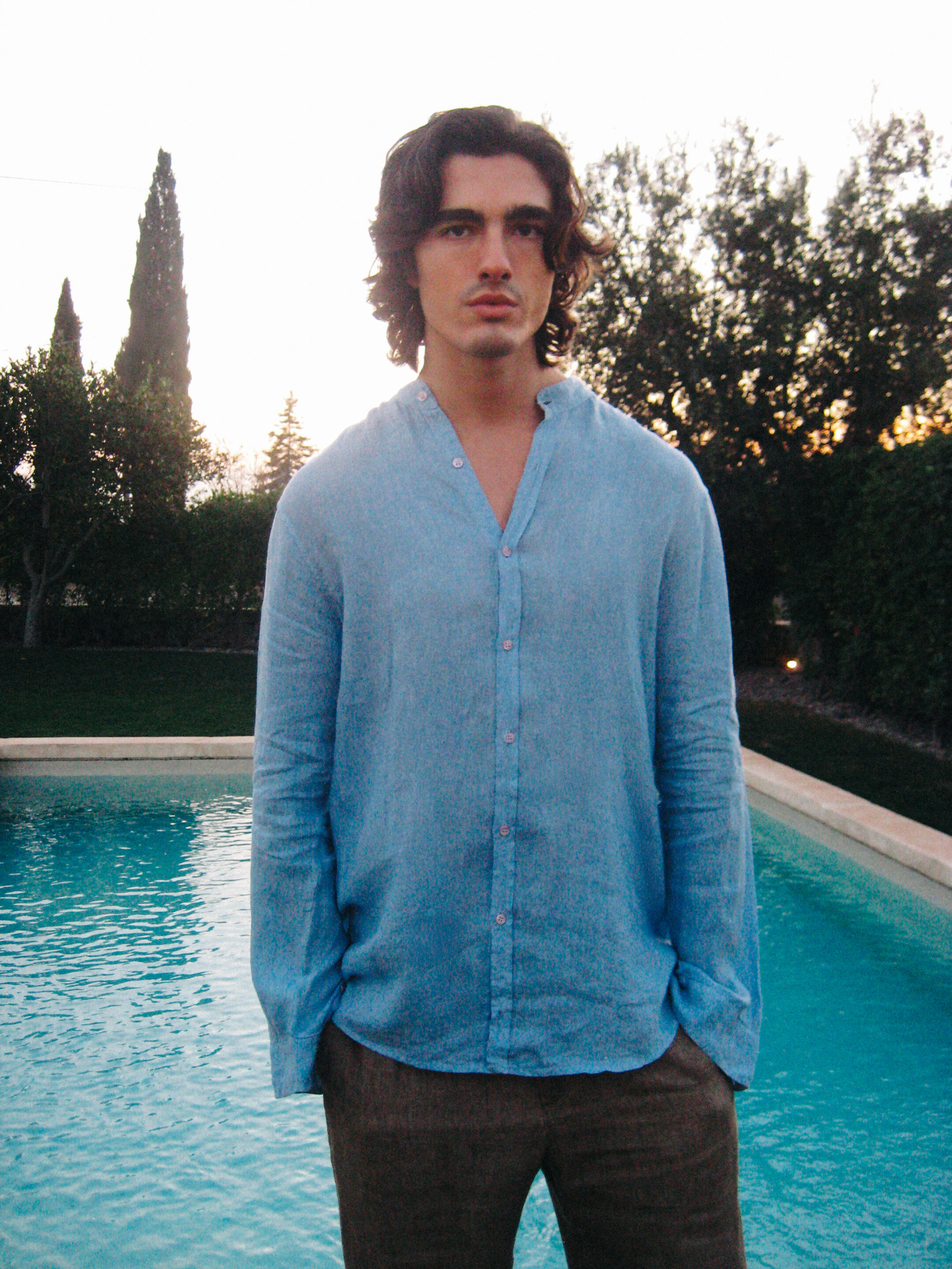 Fotógrafo le toma una fotografía a un chico delante de una piscina