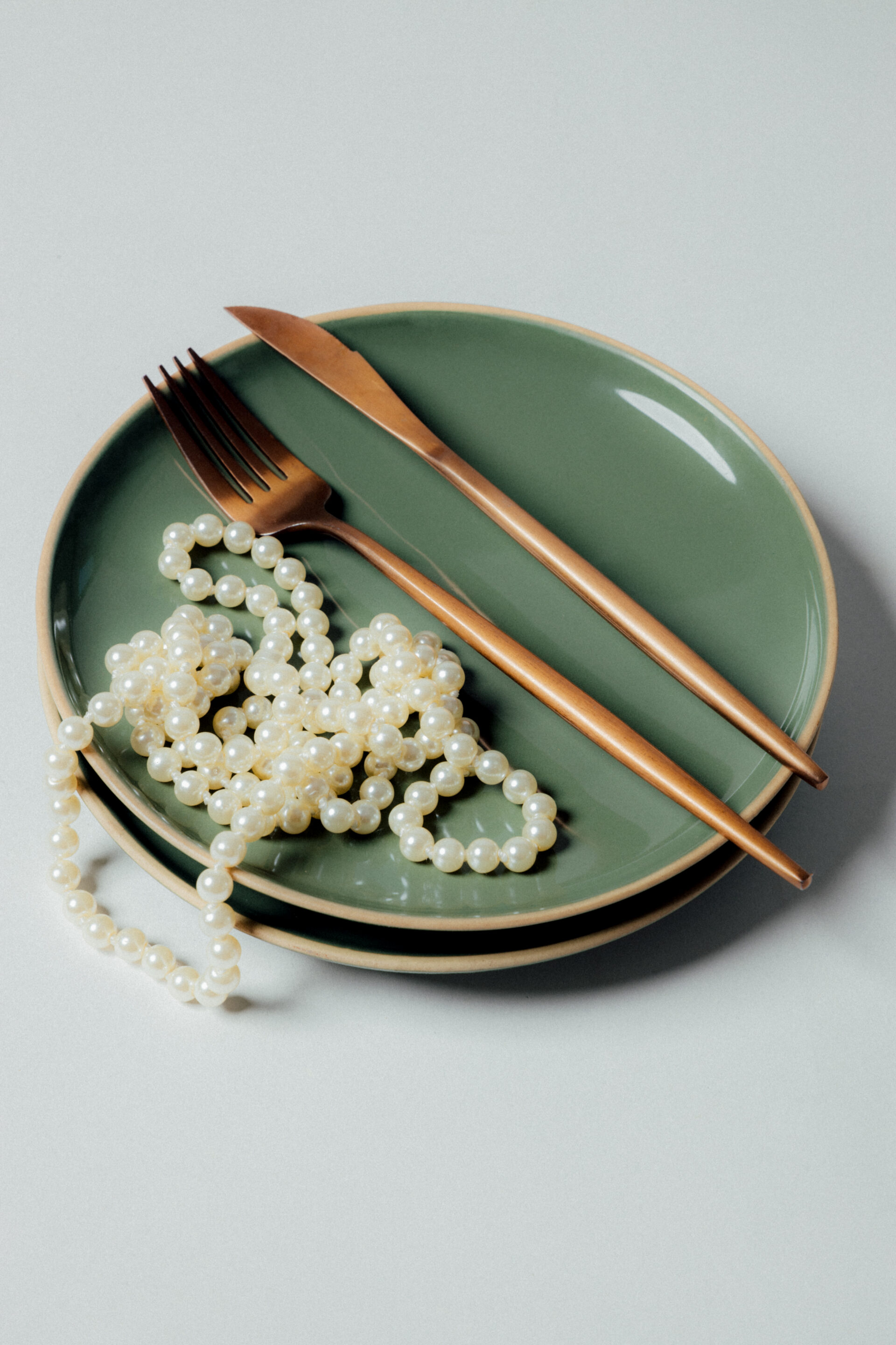 Fotógrafo le toma una foto a un plato con cubierto y perlas