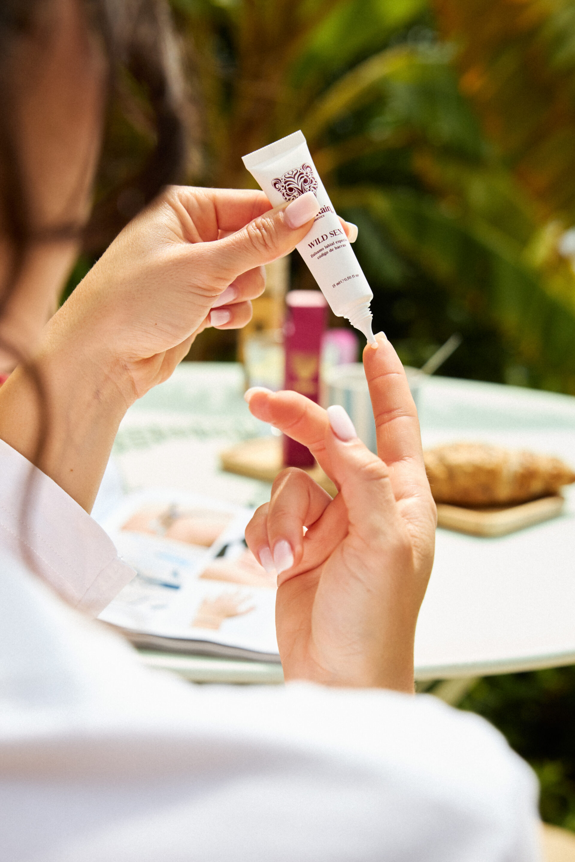 Chica poniéndose un producto skincare mientras el fotógrafo le toma una foto